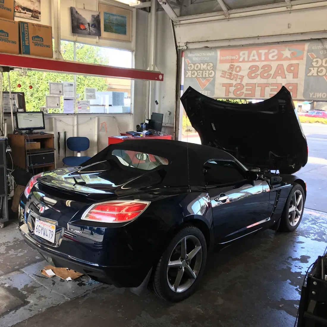Black convertible in the Redwood City Star Smog Check service bay