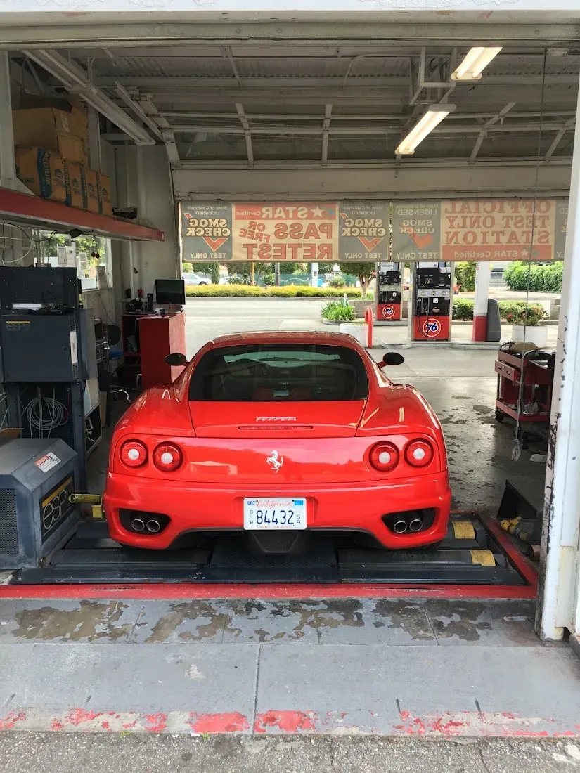 Red sports car in the Redwood City Star Smog Check inspection bay